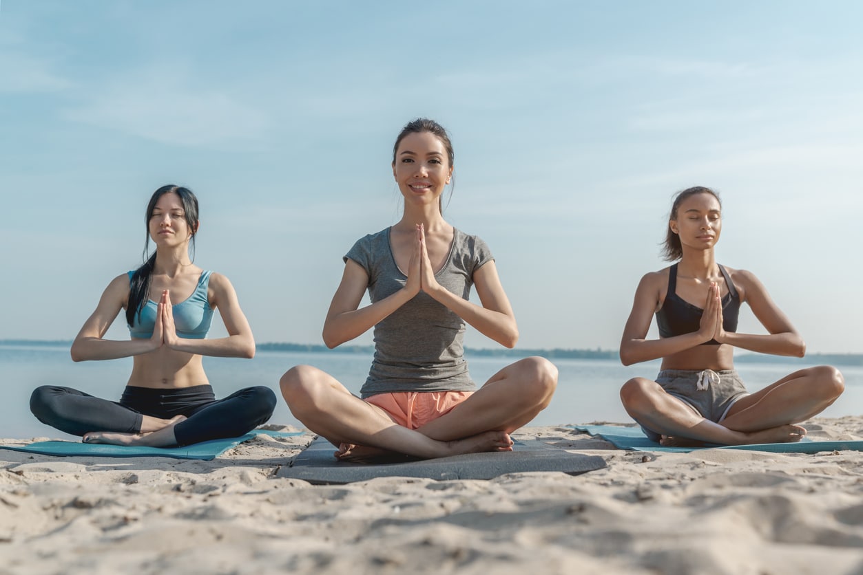 femmes sur la plage yoga méditation mer